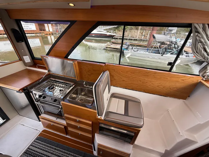  Yacht Photos Pics 2023 Cutwater C-30 Sedan NW Edition interior with kitchenette and seating, dockside view.