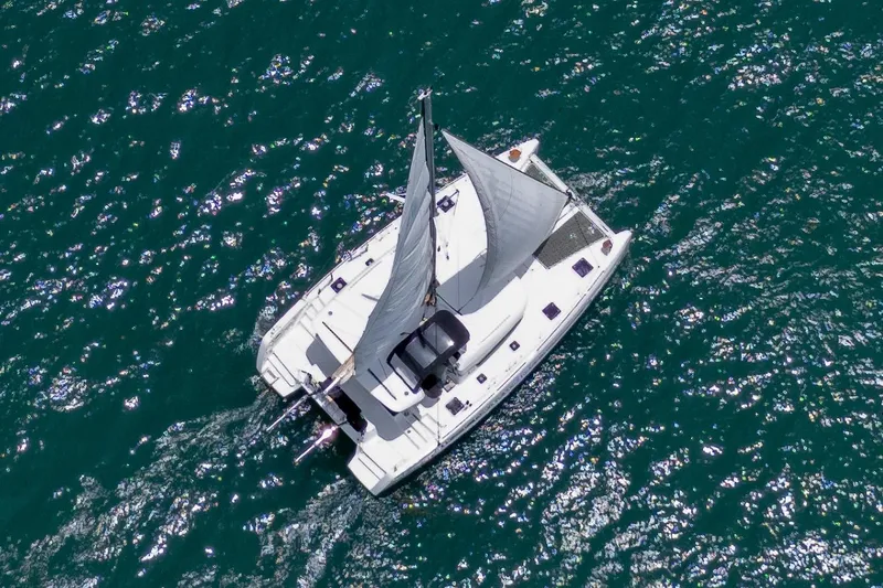 Wanderlust Yacht Photos Pics Aerial view of 2020 Lagoon 40 catamaran sailing on sparkling blue water.
