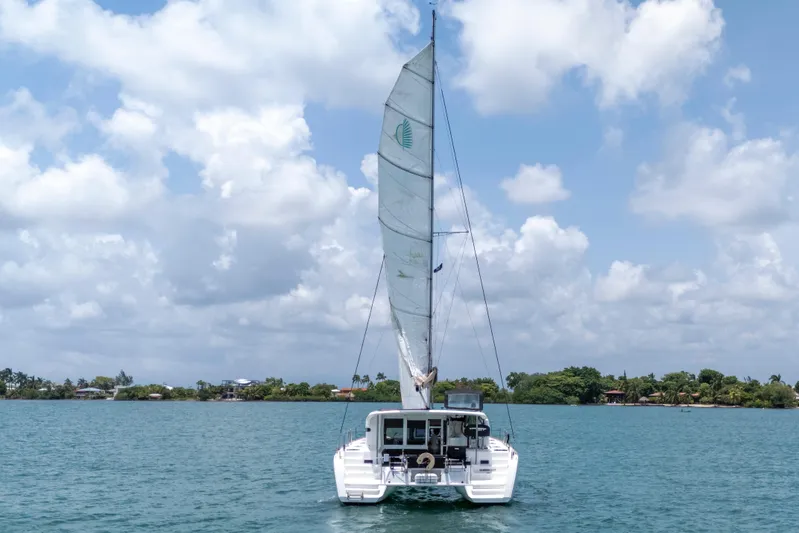 Wanderlust Yacht Photos Pics 2020 Lagoon 40 catamaran sailing on a calm sea under a partly cloudy sky.