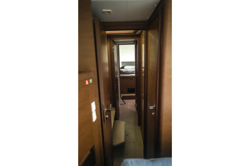 Wanderlust Yacht Photos Pics Interior hallway of 2020 Lagoon 40 catamaran, featuring wooden doors and cozy cabin view.