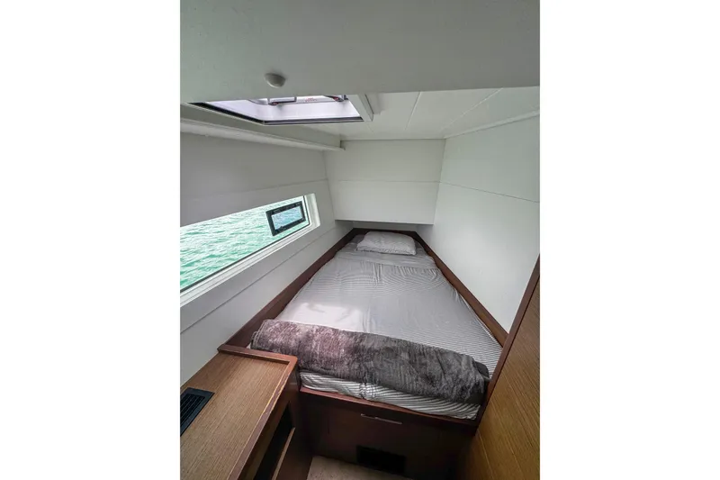 Wanderlust Yacht Photos Pics Cozy cabin interior of 2020 Lagoon 40 catamaran with bed and window view.