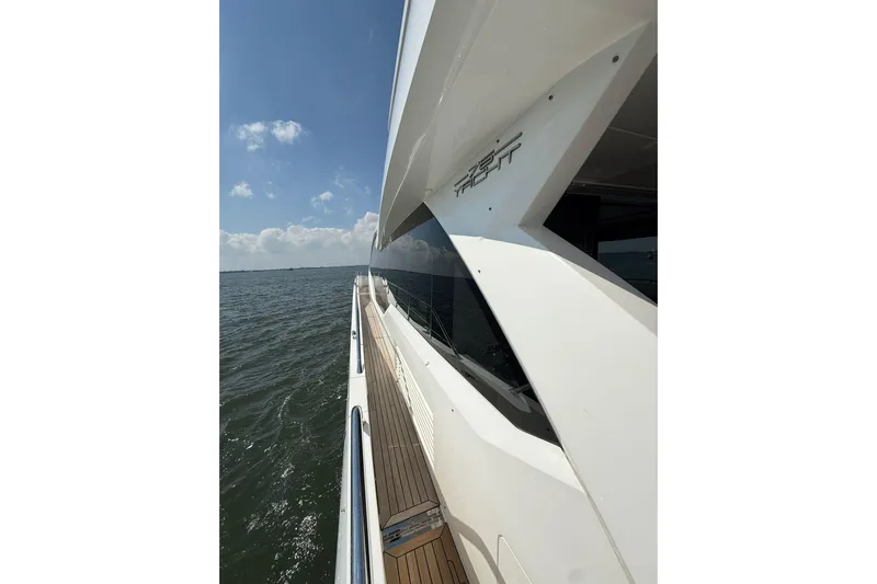  Yacht Photos Pics Side view of 2021 Sunseeker 76 Yacht cruising on open water under a clear sky.