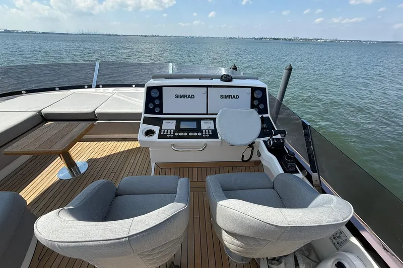  Yacht Photos Pics Luxurious 2021 Sunseeker 76 Yacht helm with Simrad navigation, overlooking serene waters.