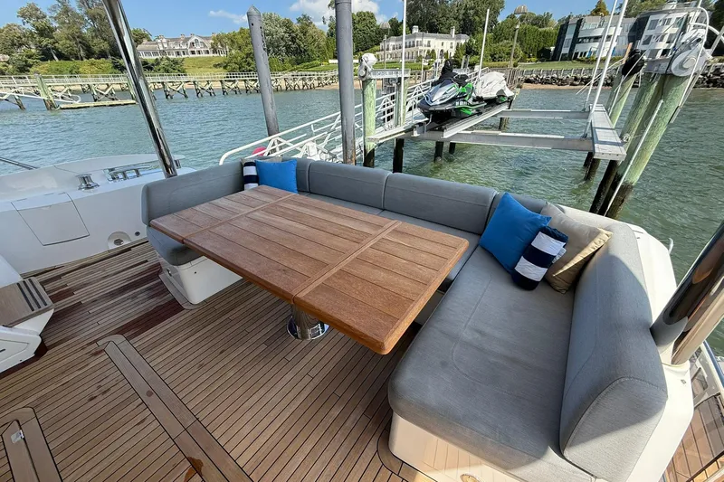  Yacht Photos Pics Luxurious Sunseeker 76 Yacht 2021 with elegant outdoor seating and scenic waterfront view.