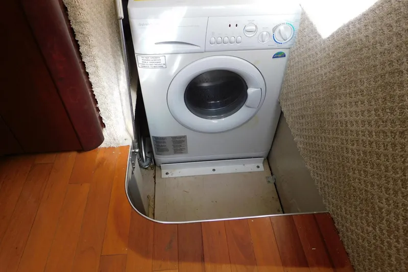 Full Deck Yacht Photos Pics Washing machine in 2008 Sea Ray 44 Sedan Bridge yacht interior, with wood and carpet flooring.