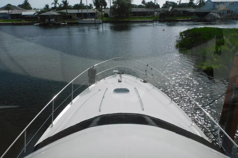 Full Deck Yacht Photos Pics 2008 Sea Ray 44 Sedan Bridge yacht on a serene waterway.