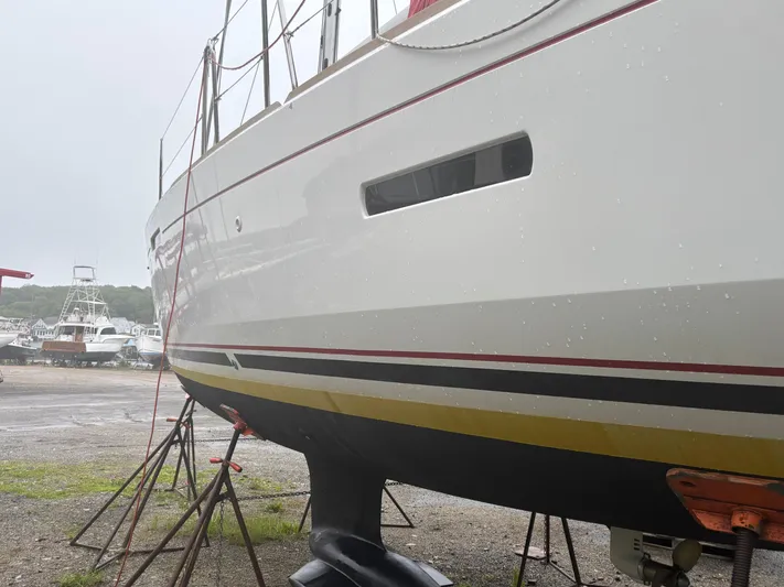 Statira Yacht Photos Pics 2017 Jeanneau Sun Odyssey 389 sailboat on stands, side view, in a boatyard.