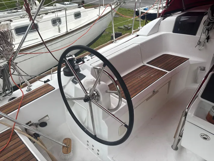 Statira Yacht Photos Pics 2017 Jeanneau Sun Odyssey 389 cockpit with steering wheel and wooden seating.