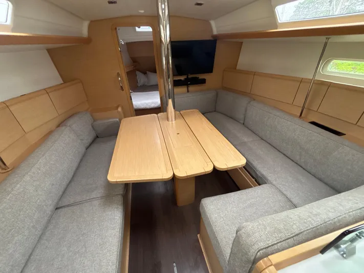 Statira Yacht Photos Pics Interior of 2017 Jeanneau Sun Odyssey 389 sailboat with cozy seating and wooden table.