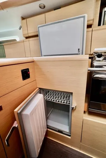Statira Yacht Photos Pics Modern kitchen area in 2017 Jeanneau Sun Odyssey 389 yacht, featuring open fridge.