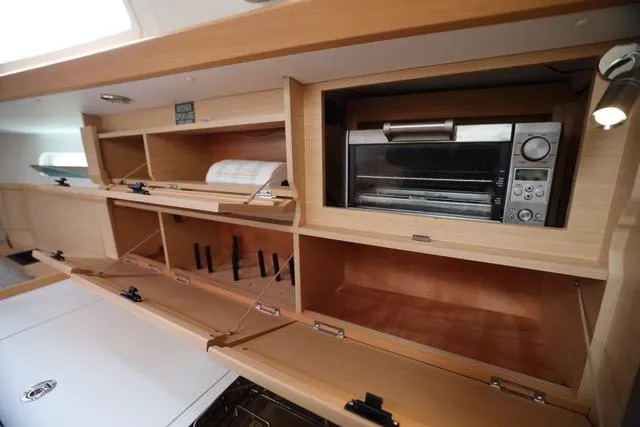 Statira Yacht Photos Pics Interior of 2017 Jeanneau Sun Odyssey 389 yacht with wooden cabinets and built-in microwave.