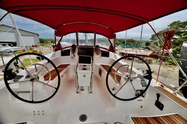 Statira Yacht Photos Pics 2017 Jeanneau Sun Odyssey 389 sailboat cockpit with dual steering wheels and red canopy.