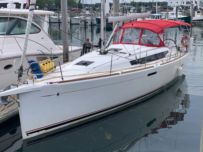 Statira Yacht Photos Pics 2017 Jeanneau Sun Odyssey 389 sailboat docked with red canopy, in a marina setting.