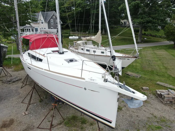 Statira Yacht Photos Pics 2017 Jeanneau Sun Odyssey 389 sailboat on land, with red canopy, near a house.