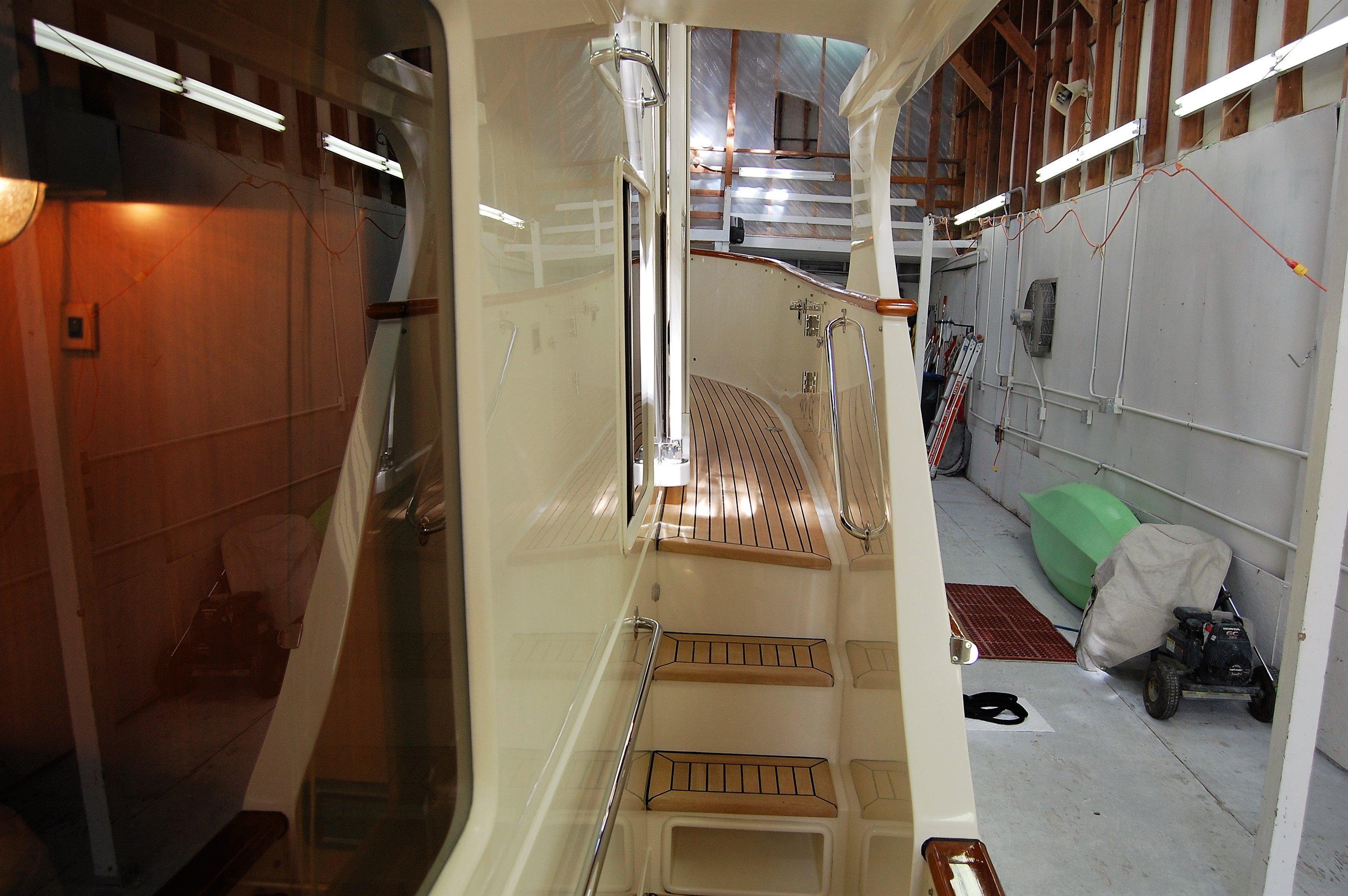 2009 Fleming Pilothouse yacht interior with wooden steps and sleek design in a storage facility.