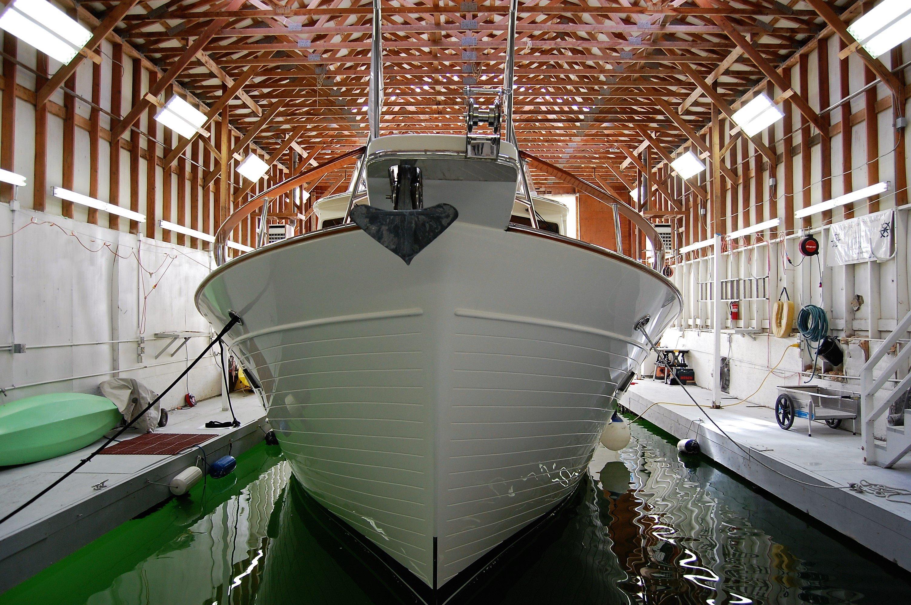 2009 Fleming Pilothouse yacht docked in a wooden boathouse, front view.