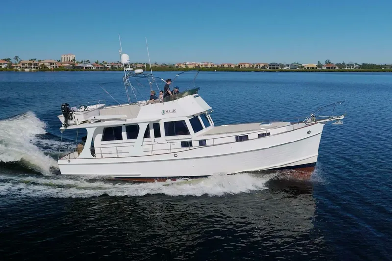 Magic Yacht Photos Pics 1996 Grand Banks 46 Europa cruising on calm waters under a clear blue sky.