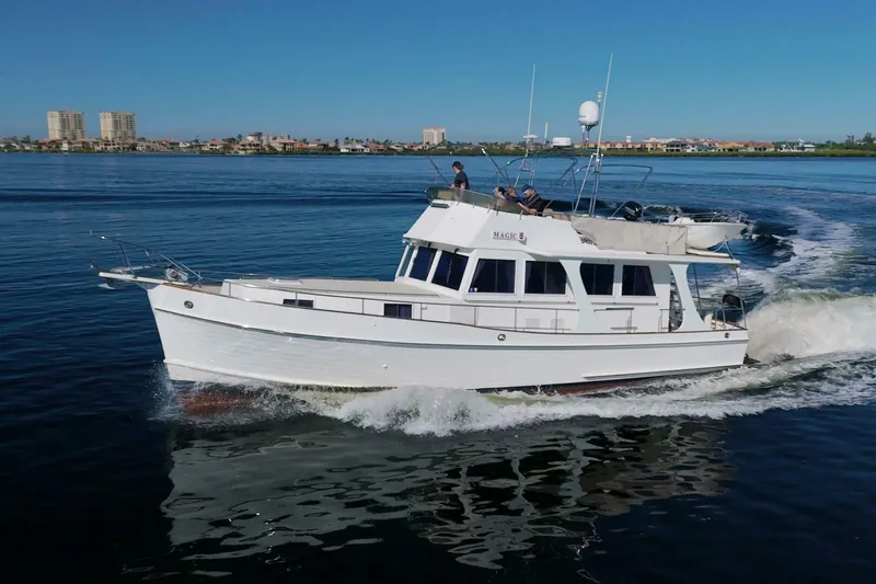 Magic Yacht Photos Pics Grand Banks 46 Europa 1996 yacht cruising on calm waters under clear skies.