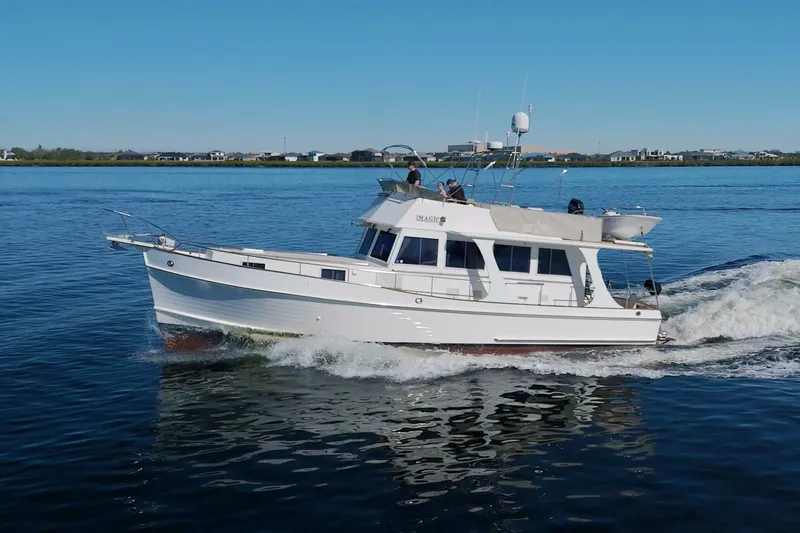 Magic Yacht Photos Pics 1996 Grand Banks 46 Europa cruising on calm waters under a clear blue sky.