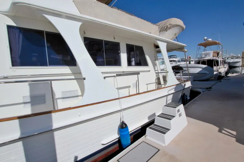 Magic Yacht Photos Pics Grand Banks 46 Europa 1996 yacht docked at marina, side view with blue fender.