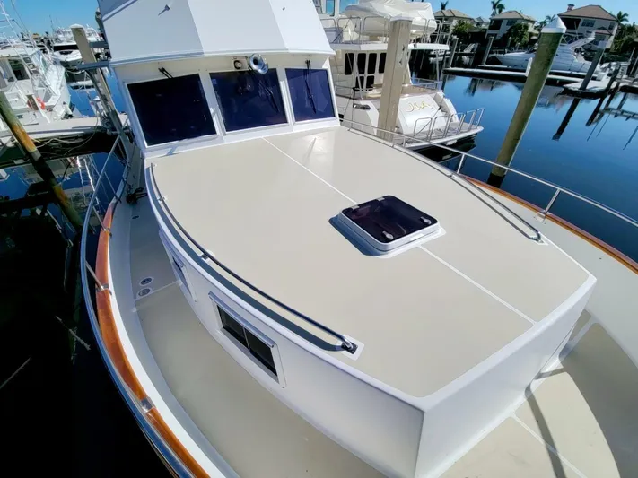 Magic Yacht Photos Pics 1996 Grand Banks 46 Europa yacht docked at marina, showcasing spacious deck and sleek design.