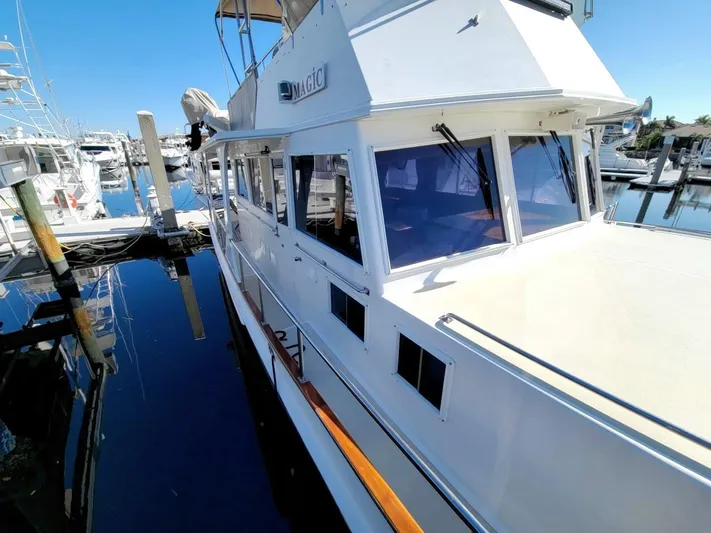 Magic Yacht Photos Pics 1996 Grand Banks 46 Europa yacht docked at marina under clear blue sky.