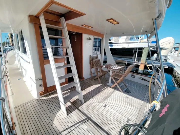 Magic Yacht Photos Pics Grand Banks 46 Europa 1996 yacht deck with seating and ladder, docked at marina.