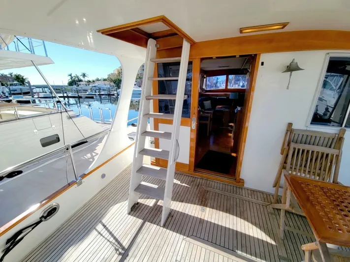Magic Yacht Photos Pics Grand Banks 46 Europa 1996 yacht deck with wooden stairs and marina view.