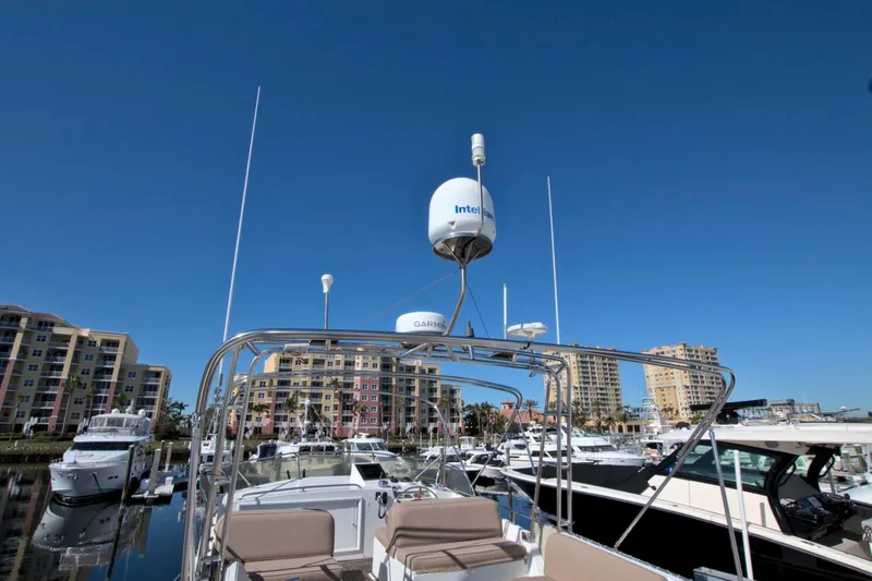 Magic Yacht Photos Pics Grand Banks 46 Europa 1996 yacht with radar equipment, docked in a marina under clear blue sky.