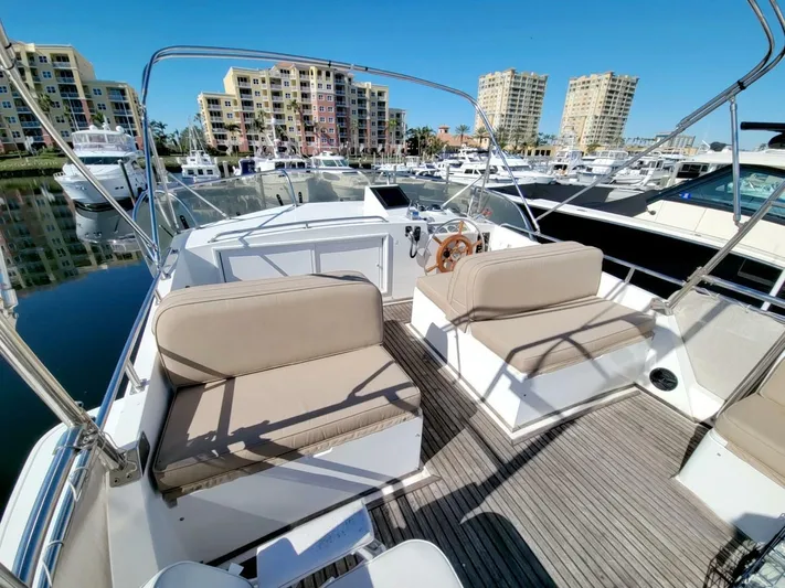 Magic Yacht Photos Pics Flybridge of 1996 Grand Banks 46 Europa yacht docked in marina, featuring seating and helm.