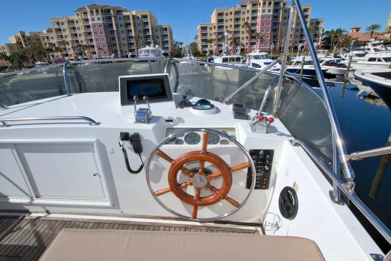 Magic Yacht Photos Pics 1996 Grand Banks 46 Europa yacht helm with wooden steering wheel, docked in marina.