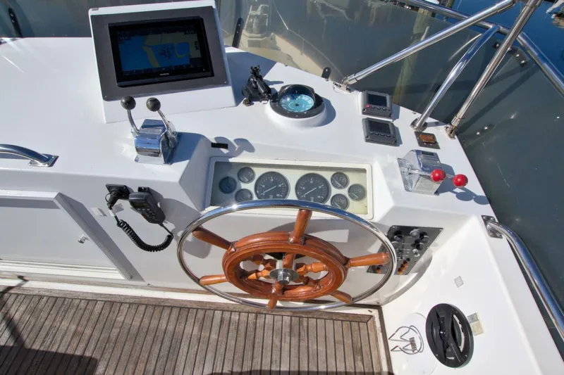 Magic Yacht Photos Pics Helm of 1996 Grand Banks 46 Europa yacht with wooden wheel and navigation instruments.