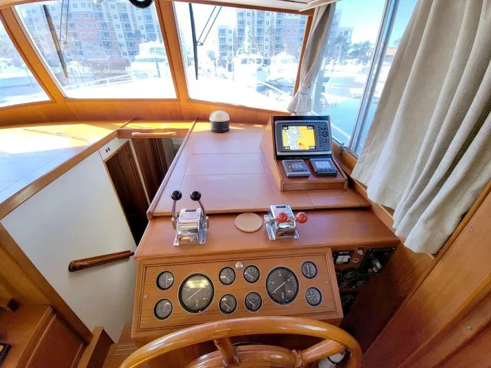 Magic Yacht Photos Pics Helm of 1996 Grand Banks 46 Europa yacht with navigation instruments and wooden steering wheel.