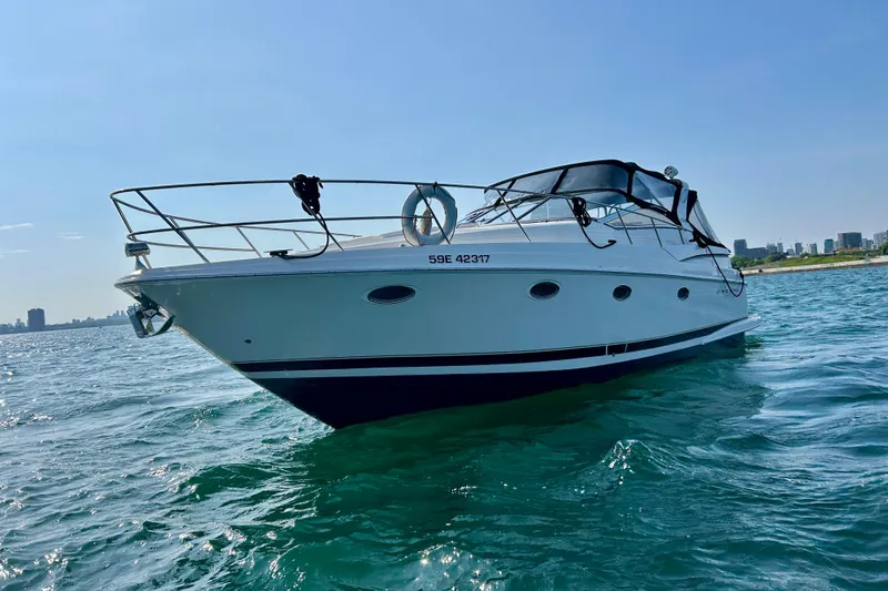 Done Deal Yacht Photos Pics 2002 Regal Commodore 3860 yacht on open water with city skyline in background.