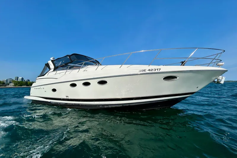Done Deal Yacht Photos Pics 2002 Regal Commodore 3860 yacht cruising on clear blue water under a sunny sky.