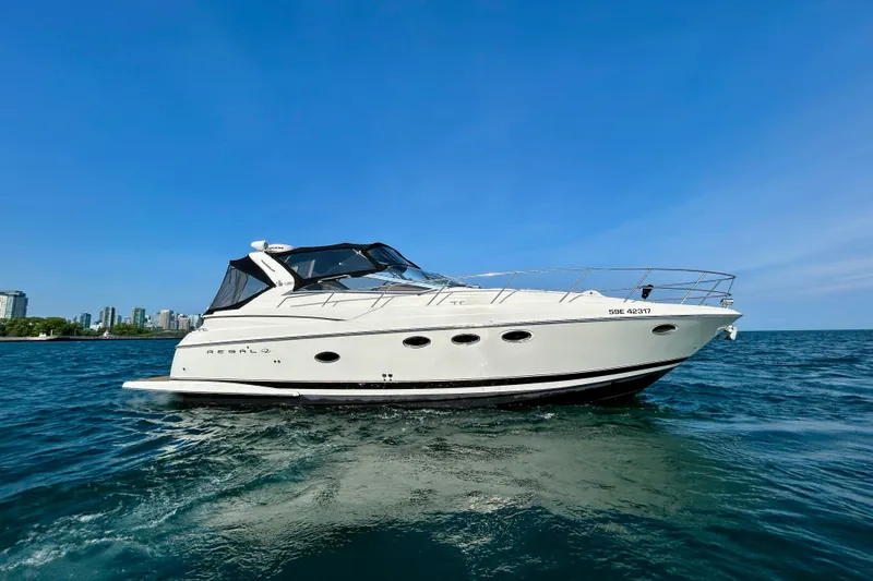 Done Deal Yacht Photos Pics 2002 Regal Commodore 3860 yacht cruising on open water under clear blue sky.