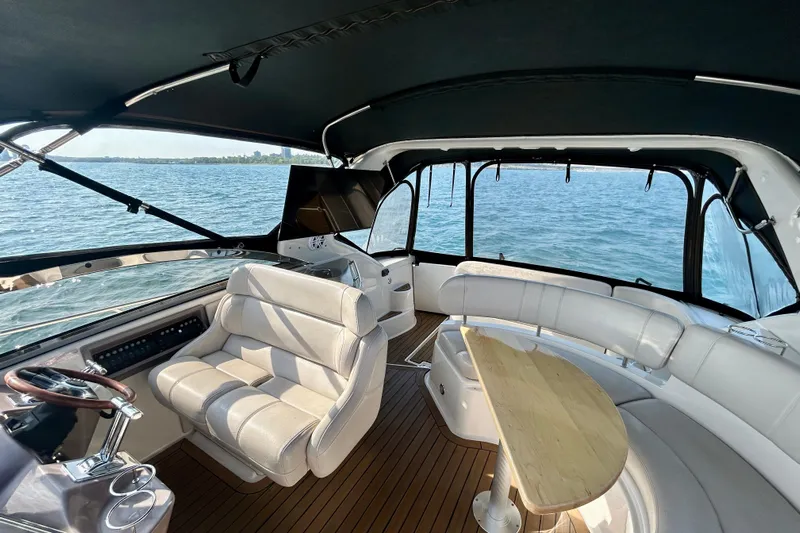 Done Deal Yacht Photos Pics 2002 Regal Commodore 3860 yacht interior with seating and table on open water.