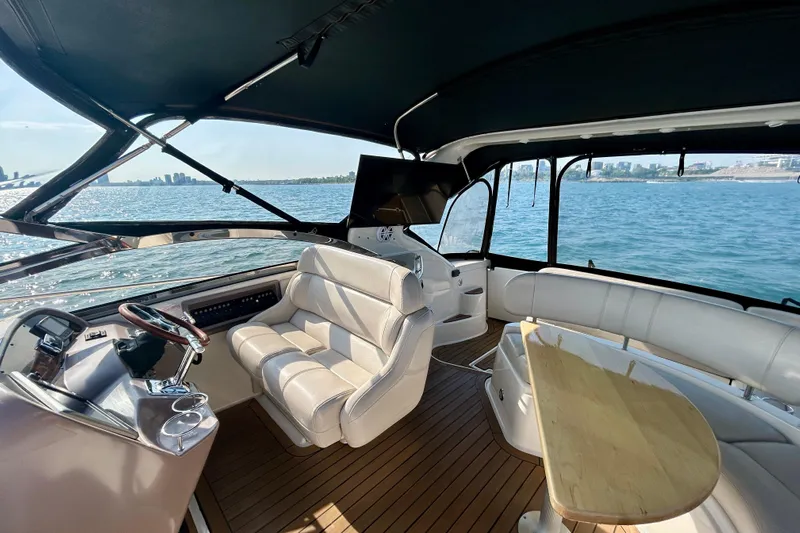 Done Deal Yacht Photos Pics Luxurious interior of 2002 Regal Commodore 3860 yacht with leather seating and wooden table.