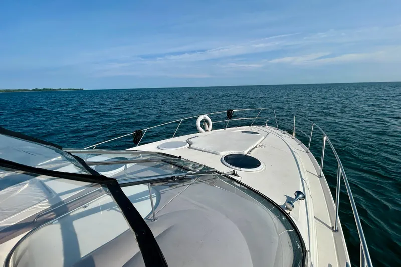 Done Deal Yacht Photos Pics 2002 Regal Commodore 3860 yacht cruising on open sea under clear blue sky.