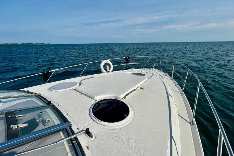 Done Deal Yacht Photos Pics 2002 Regal Commodore 3860 yacht cruising on open sea under clear blue sky.