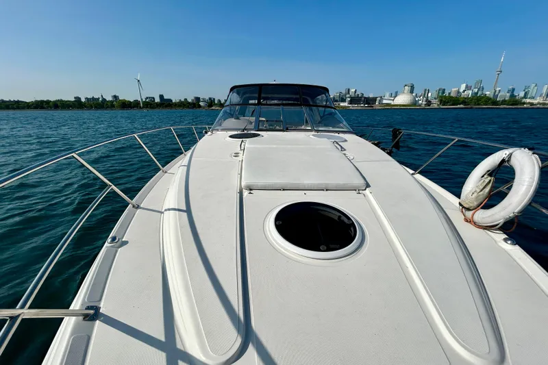 Done Deal Yacht Photos Pics 2002 Regal Commodore 3860 yacht on water with city skyline in background.