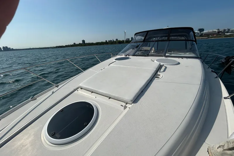 Done Deal Yacht Photos Pics 2002 Regal Commodore 3860 yacht on open water, clear sky, city skyline in background.