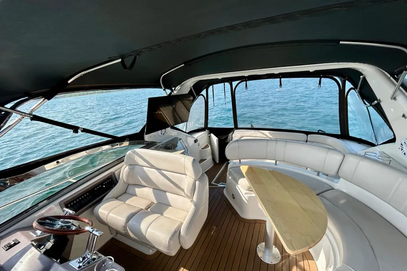 Done Deal Yacht Photos Pics Interior of 2002 Regal Commodore 3860 yacht with seating and table, overlooking the ocean.