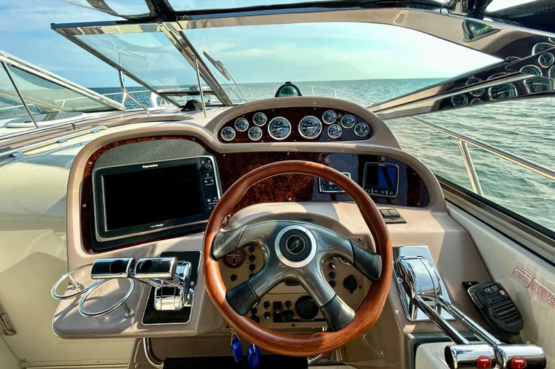 Done Deal Yacht Photos Pics Cockpit view of 2002 Regal Commodore 3860 yacht with steering wheel and navigation instruments.