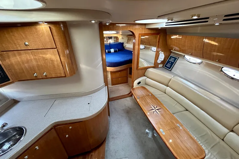 Done Deal Yacht Photos Pics Luxurious interior of 2002 Regal Commodore 3860 yacht with wood finishes and cozy seating.