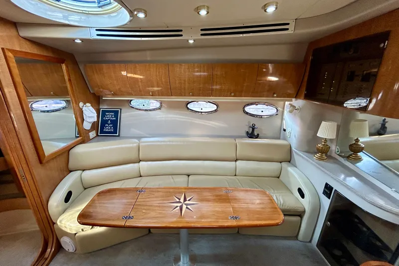 Done Deal Yacht Photos Pics Luxurious interior of 2002 Regal Commodore 3860 yacht with leather seating and wooden table.