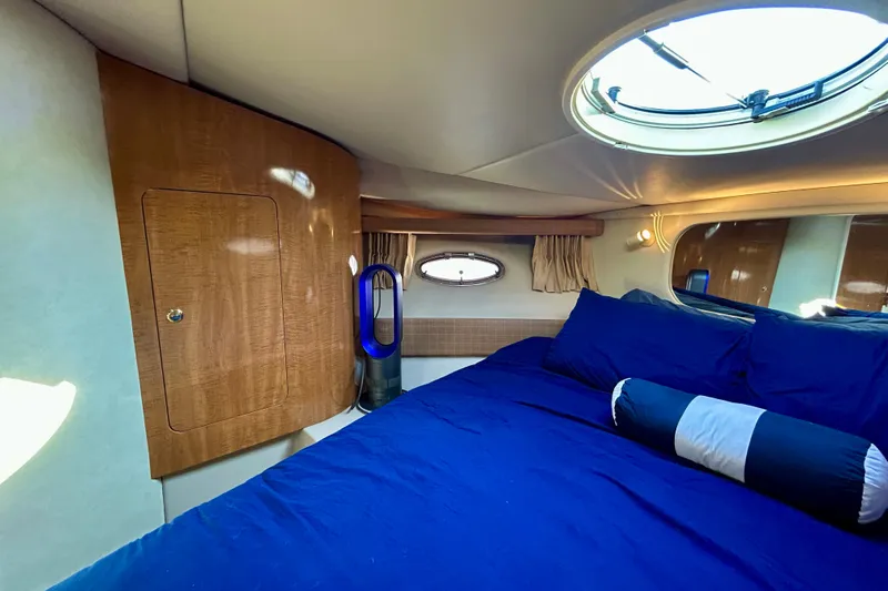 Done Deal Yacht Photos Pics Luxurious cabin interior of 2002 Regal Commodore 3860 yacht with blue bedding and porthole.