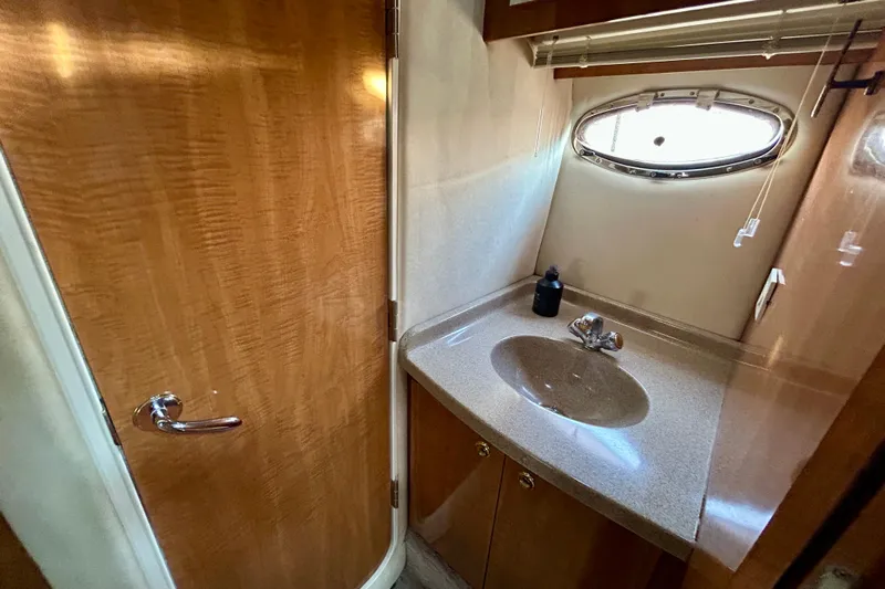 Done Deal Yacht Photos Pics 2002 Regal Commodore 3860 yacht bathroom with wooden door and oval window.