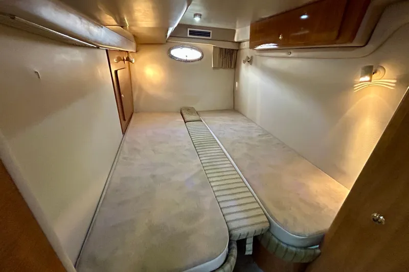 Done Deal Yacht Photos Pics Interior cabin of 2002 Regal Commodore 3860 yacht, featuring cozy twin beds and ambient lighting.