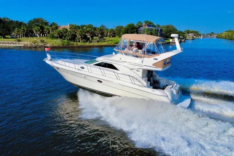 Lighten Up Yacht Photos Pics 2003 Sea Ray 400 Sedan Bridge cruising on a scenic waterway under clear blue skies.